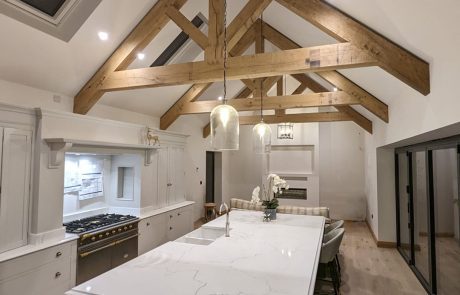 Completed kitchen renovation with exposed oak roof trusses and large central island
