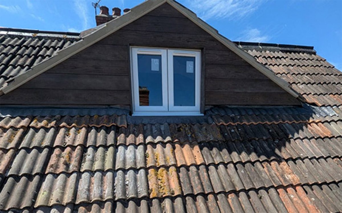 Completed dormer loft conversion with timber cladding and white framed window